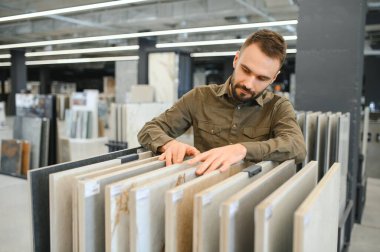 Depodaki farklı örnekler arasından fayans seçen adam.