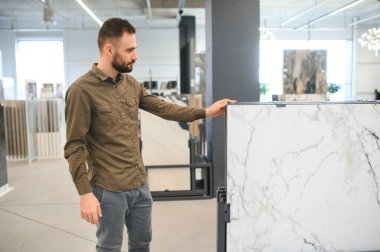 Erkek müşteri mutfaktaki seramik fayansı seçiyor..