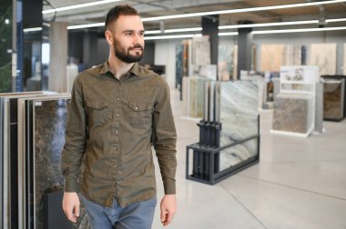 Depodaki farklı örnekler arasından fayans seçen adam.