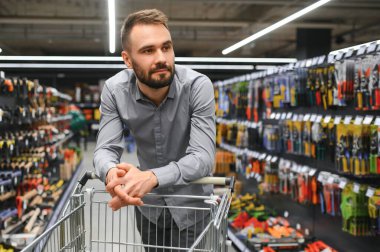 Hırdavatçıdaki erkek müteahhit bir araç seçer.