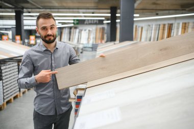 Hırdavatçıda döşemeyi seçen adam.