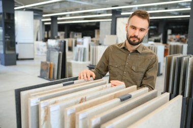 Erkek müşteri mutfaktaki seramik fayansı seçiyor..