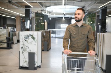 Depodaki farklı örnekler arasından fayans seçen adam.