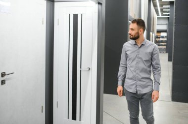 Alıcı mağazadaki kapıyı seçer. Kapıların penceresi. Ev için geniş bir kapı seçimi..