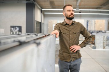 İnşaat malzemeleri mağazasında seramik fayans seçen yakışıklı bir adam..