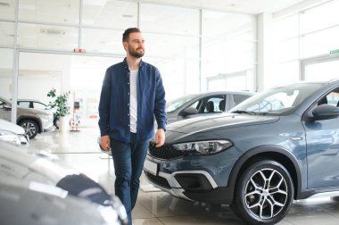 Yetişkin müşteri erkek müşteri müşterisi otomobil seçmek istiyor galeri araç galerisi galerisi galerisi kapalı motor fuarında yeni bir otomobil dokunulmaz araba almak istiyor. Satış konsepti