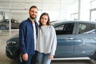 Araba galerisinde yeni bir araba seçen güzel bir çiftin portresi..