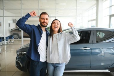 Araba galerisinde yeni bir araba seçen güzel bir çiftin portresi..