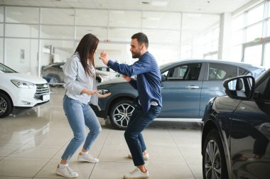 Heyecanlı eşler, yeni araba aldıktan sonra galeride dans ediyorlar..