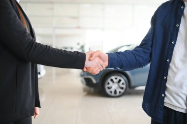 Kadın araba satıcısıyla el sıkışıyor..