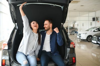 Birlikte ilk büyük alışverişimiz. Bir araba kuaföründe sarılan mutlu genç bir çiftin portresi..