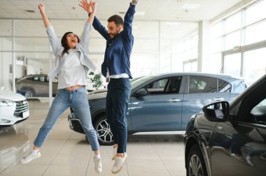 Heyecanlı eşler, yeni araba aldıktan sonra galeride dans ediyorlar..