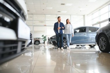 Araba galerisinde yeni bir araba seçen güzel bir çiftin portresi..