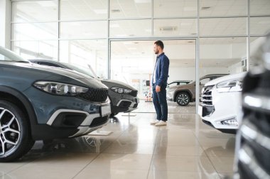 Yetişkin müşteri erkek müşteri müşterisi otomobil seçmek istiyor galeri araç galerisi galerisi galerisi kapalı motor fuarında yeni bir otomobil dokunulmaz araba almak istiyor. Satış konsepti
