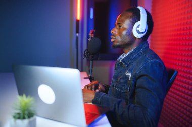 Radyo programını kaydederken mikrofona konuşan yakışıklı Afrikalı Amerikalı adam..