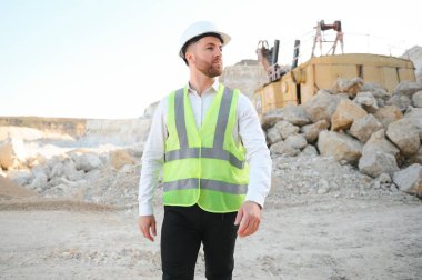 Kum ocağında buldozer taşıyan erkek işçi.