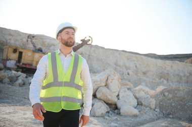 Kum ocağında buldozer taşıyan erkek işçi.