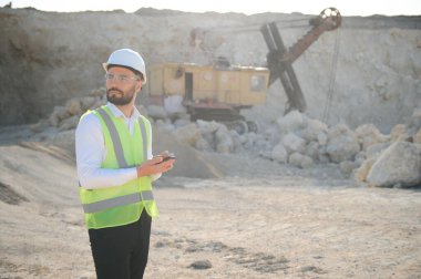 Kum ocağında buldozer taşıyan erkek işçi.