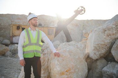 Taşın çıkarılması. Taş ocağının yanındaki erkek işçi. İnşaat alanında mühendis..