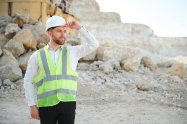 Kum ocağında buldozer taşıyan erkek işçi.