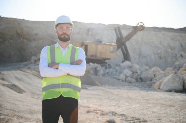 Kum ocağında buldozer taşıyan erkek işçi.