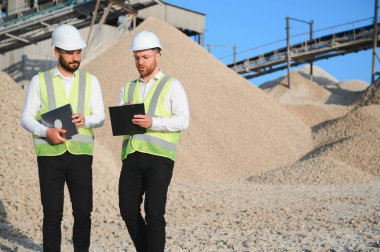 Endüstriyel bir fabrikada iki mühendis ya da işadamı. Çakıl çıkarmak ve üretmek için fabrika.