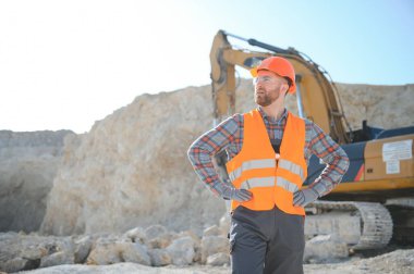 Taşın çıkarılması. Taş ocağının yanındaki erkek işçi. İnşaat alanında mühendis..