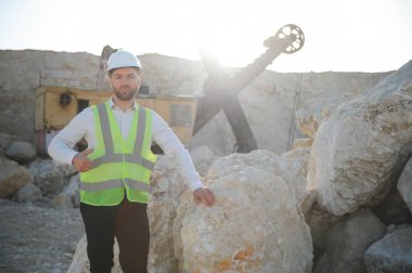 Arkaplanda işçi ve taş ocağı.