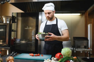 Büyük bir Restoran Hazırlık Tabakları Şefi. Modern Mutfak Paslanmaz Çelik ve Mutfak Malzemeleriyle Doludur.