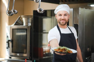 İşimi seviyorum Lokanta mutfağında duran neşeli genç şef.