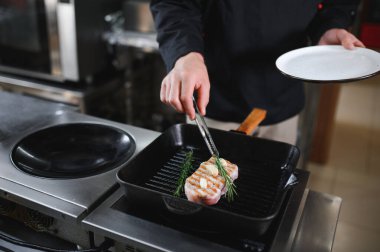 Şef domuz bifteği pişirir. Yemek tarifi kitabı, yemek pişirme, restoran işi..