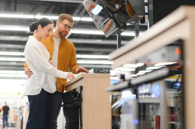 Genç bir çift süpermarketten yeni gaz sobası alıyor..