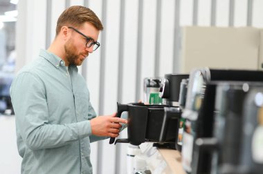 Elektrikçide çömlek seçen adam.