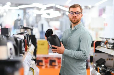 Elektrikli su ısıtıcısını seçen adam.