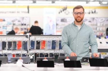 Tabletle dükkânda alet seçen bir müşteri.