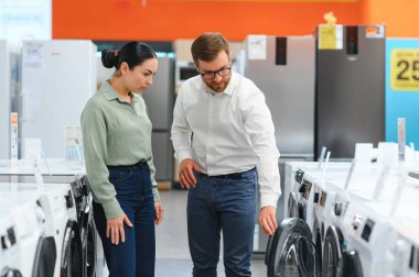 Perakende Ev Elektronik Uzmanından Tavsiye İsteyen Bir Kadın Müşterinin Portresi.