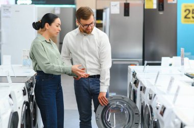 Perakende Ev Elektronik Uzmanından Tavsiye İsteyen Bir Kadın Müşterinin Portresi.