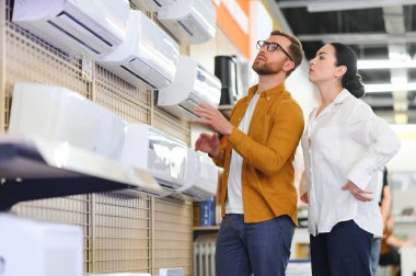 Güzel bir çift bir elektronik mağazasından klima seçiyor..