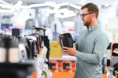 Elektrikli su ısıtıcısını seçen adam.