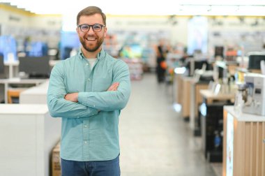 Elektronik mağazasında mutlu bir adam. Büyük indirimler..