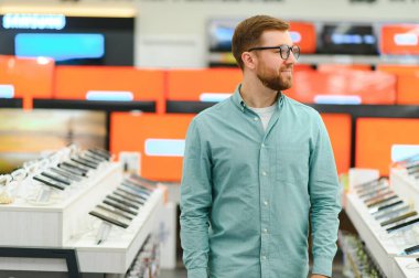 Ev aletleri dükkanında sakallı yakışıklı bir adamın portresi..