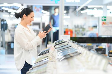 Teknoloji mağazasından yeni akıllı telefon almak. Yeni bir teknolojik cihaz arıyorum..