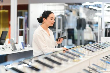 Teknoloji mağazasından yeni akıllı telefon almak. Yeni bir teknolojik cihaz arıyorum..