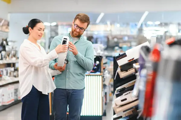 stock image Couple buying wireless vacuum cleaner at store.