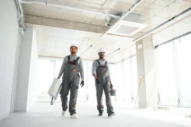 Çok ırklı bir grup inşaat inşaat işçisi iş yerinde toplanıyor..