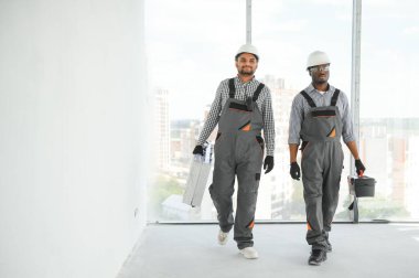 Çok ırklı bir grup inşaat inşaat işçisi iş yerinde toplanıyor..