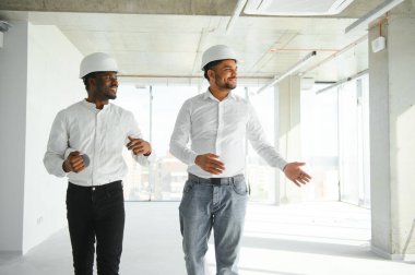 Mühendisler inşaat alanını incelerken tartışıyorlar..