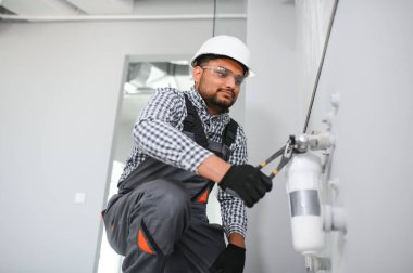 Hint Tesisatçısı su filtresi yükler veya değiştirir.