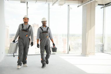 İnşaat alanında çok kültürlü inşaat işçileri..