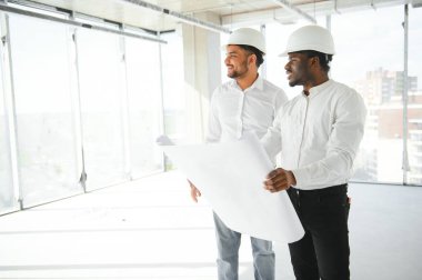 Mühendisler inşaat alanını incelerken tartışıyorlar..